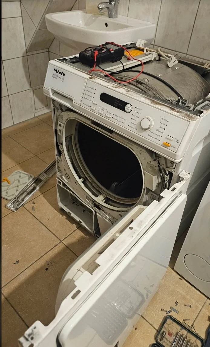 Pralka ze zdemontowanym frontem i obudową podczas diagnozy podzespołów